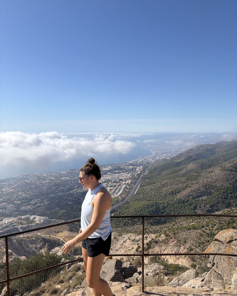 Hannah on a mountain viewpoint above the clouds